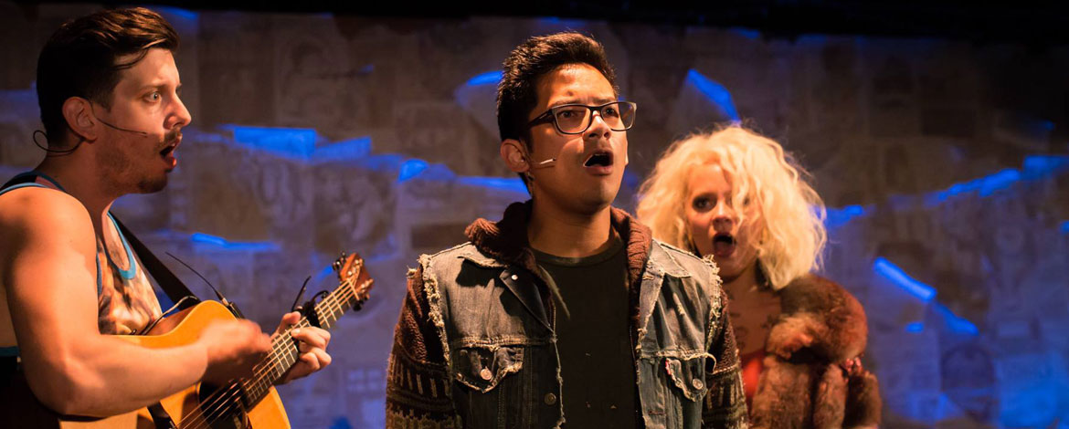 Justin Huertas '09 (center) performs in "Lizard Boy" at the Diversionary Theatre in San Diego. He wrote the musical for Seattle Repertory Theatre in 2015. Huertas is flanked by Kirsten deLohr Helland ’10 (right) and William A. Williams. The cast performed as a three-person folk rock band. (Photo by Simpatika, courtesy of Diversionary Theatre)