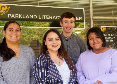 Four PLU Students posing in front of the Parkland Literacy Center