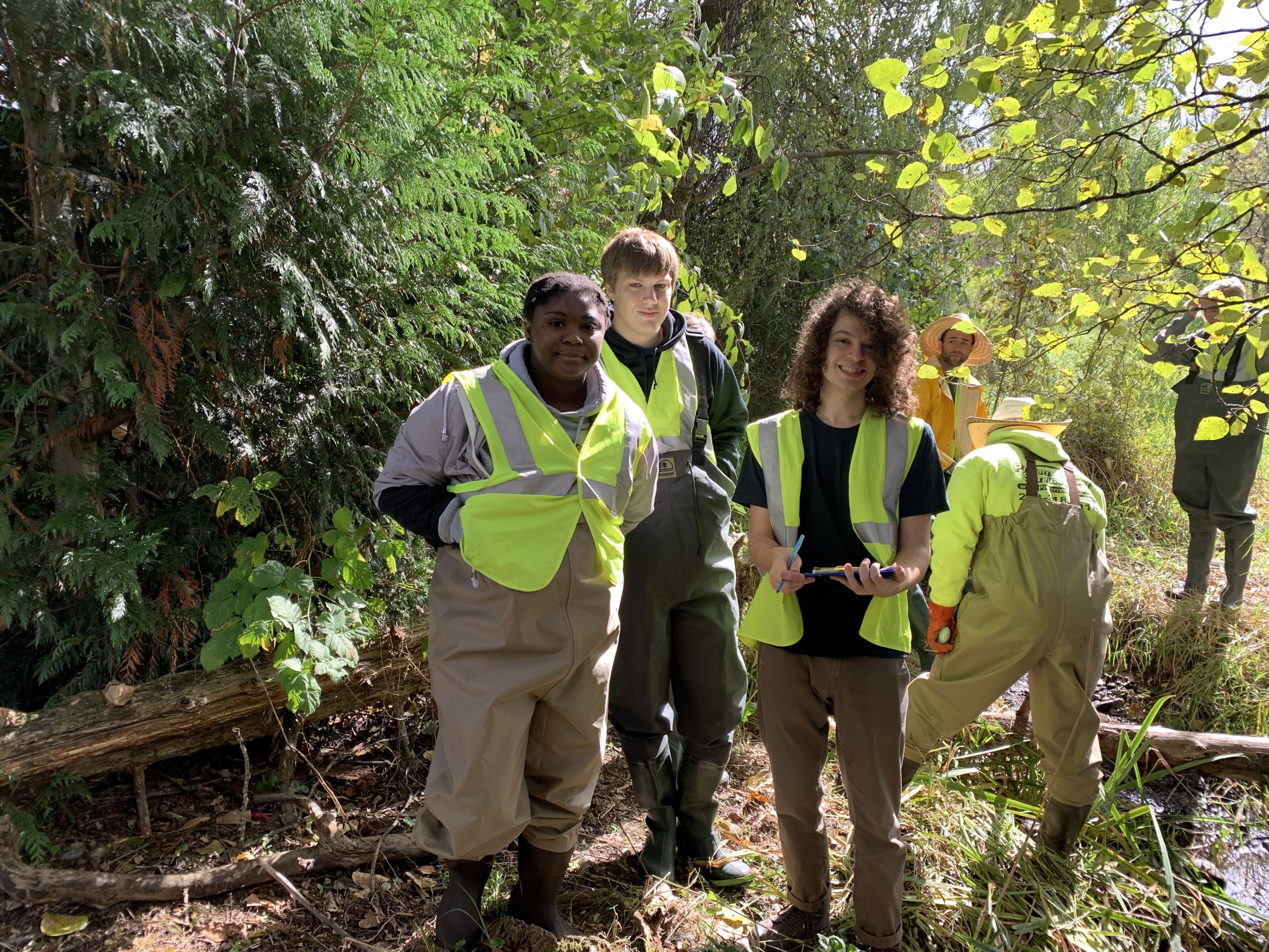 Photos of PLU students collecting samples near a stream bed.