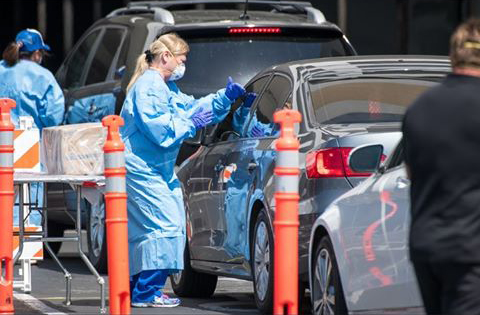 Krogstad dispenses self-tests to prospective patients at the mobile testing unit through their vehicle windows. Krogstad dispenses self-tests to prospective patients at the mobile testing unit through their vehicle windows.