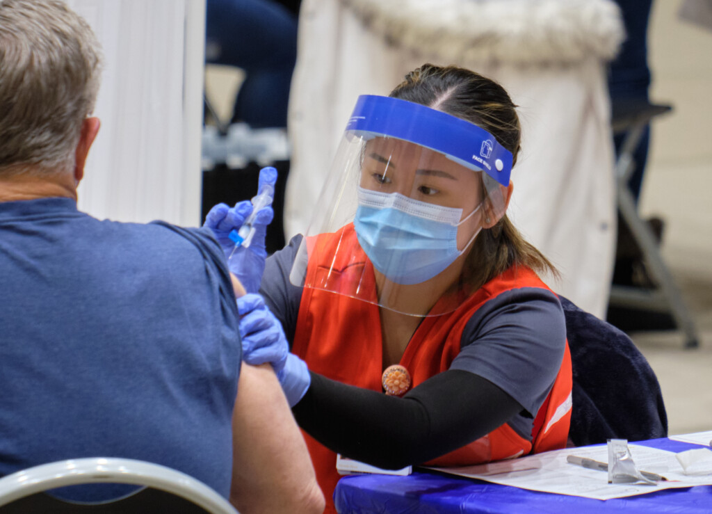 covid-vaccinations-2-11-21-786 Wearing a mask, face shield and other nursing attire, a PLU nursing student administers a COVID-19 vaccination.