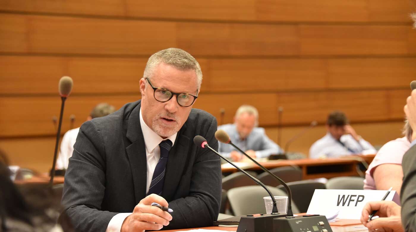 PLU alumnus Brian Lander speaks into a microphone while seated at a desk at a United Nations event.