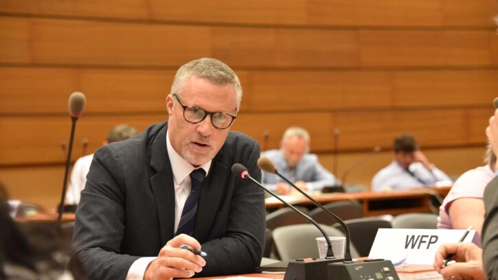 PLU alumnus Brian Lander speaks into a microphone while seated at a desk at a United Nations event.