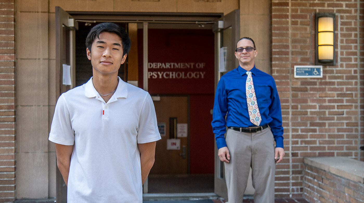 Prof Jon Grahe and student Ricky Handeda stand outside the Department of Psychology office in Ramstad Hall.