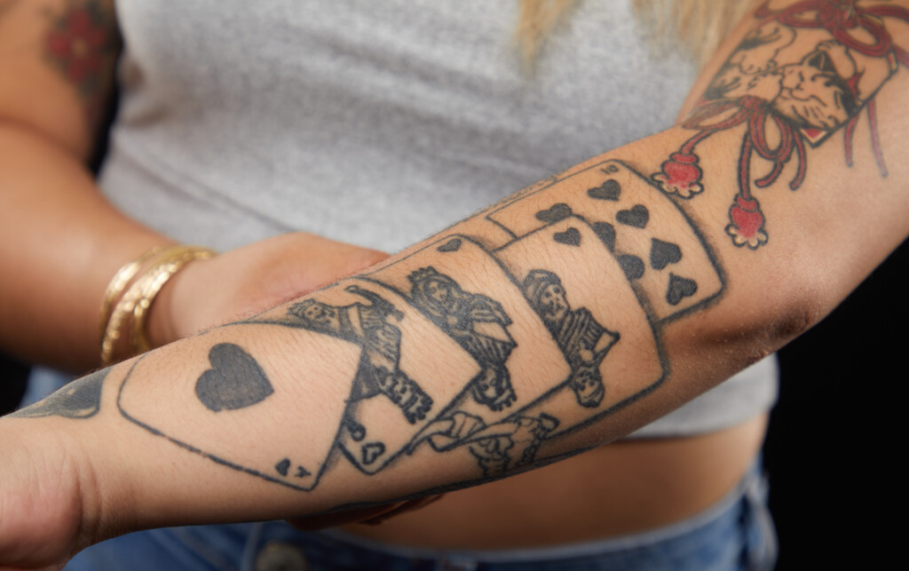 close up photo of a tattoo of a playing cards on April's arm.