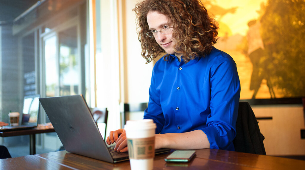 Conover typing on this laptop. He's seated in a coffee shop, a Starbucks up is just a few inches from his computer