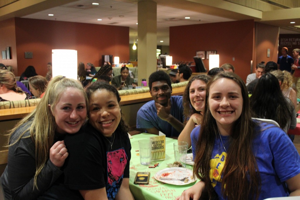 five PLU students take a break from eating dinner in the dining hall to take a quick photo.