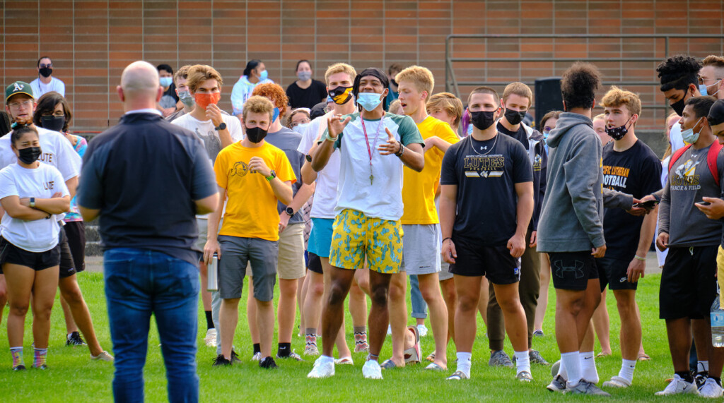 students in athletic clothes gather in the field to play some community games