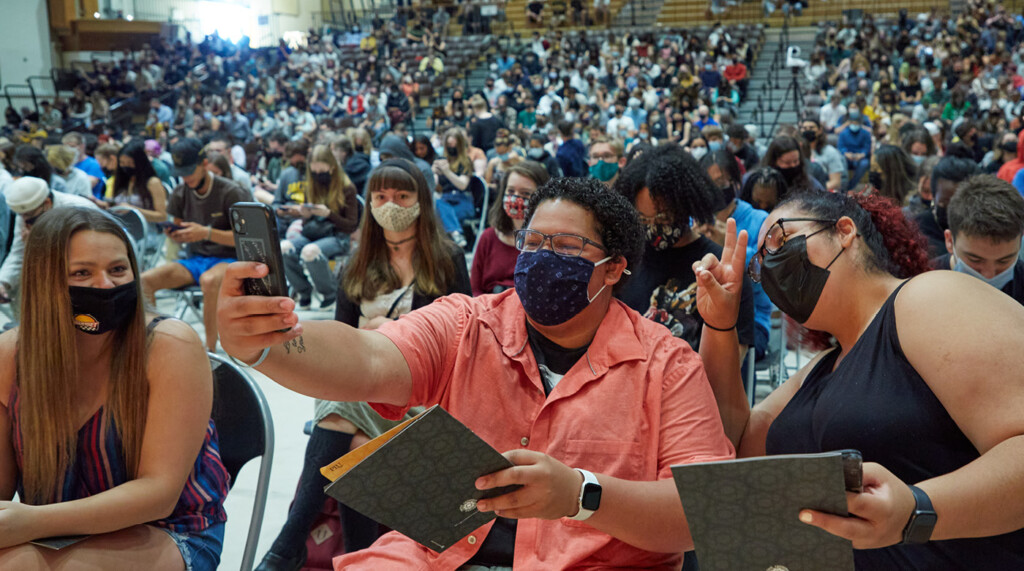 Lutes wearing protective masks take a selfie in the gym before the start of the convocation ceremony.