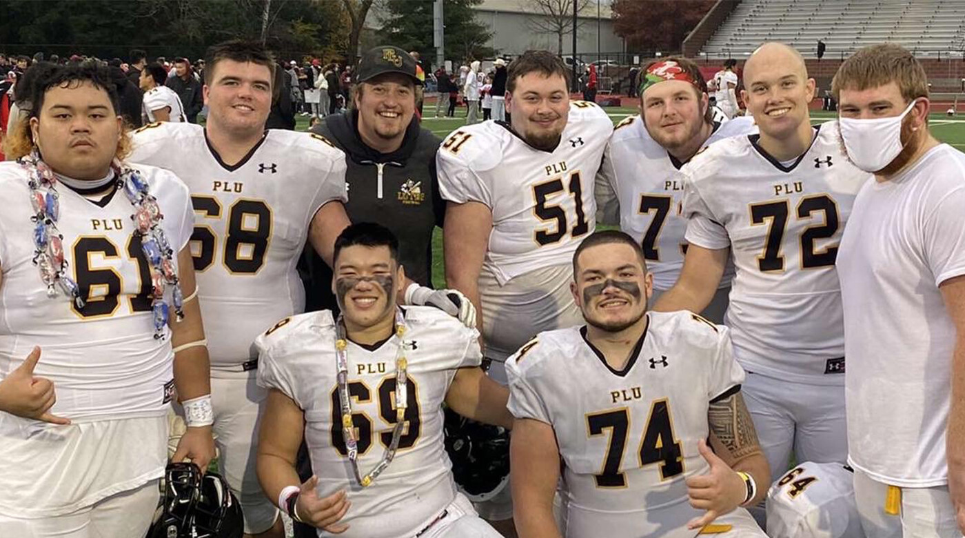 9 members of PLU football team poses on field for a picture together