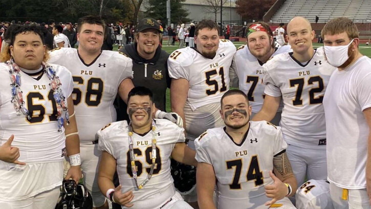 9 members of PLU football team poses on field for a picture together