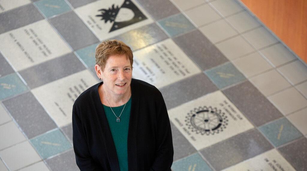 Teri Card in the lobby of her office building looking up at the photographer on a balcony.