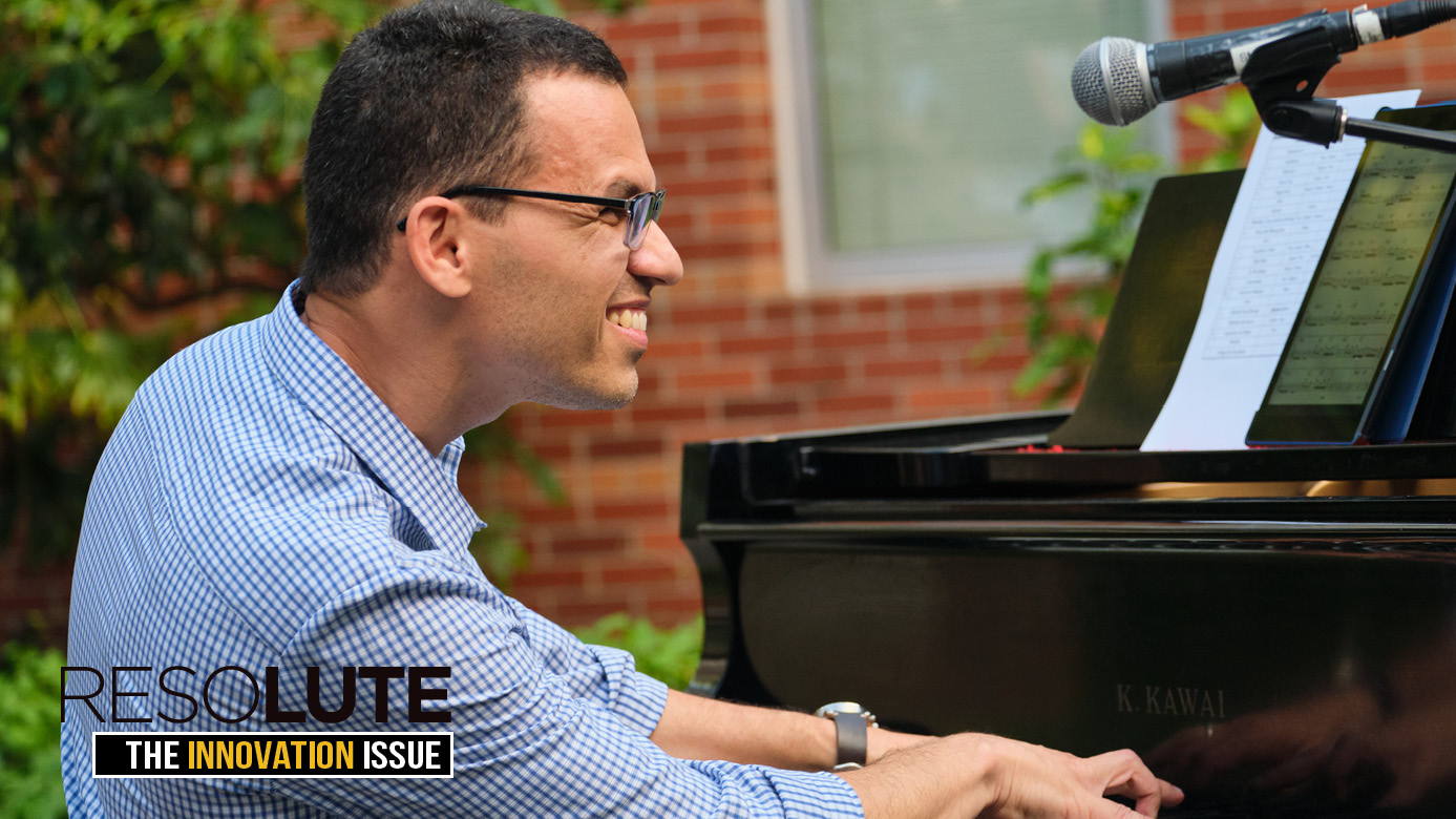 Cassio smiles while playing the piano at a performance in ampitheatre outside the PLU music building.