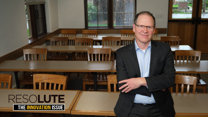 Mike Halverson leans back against a table in an empty PLU classroom in Xavier Hall