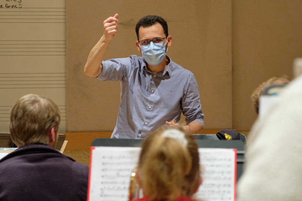 Vianna waves his hand as gives instruction to the jazz ensemble in a practice room.