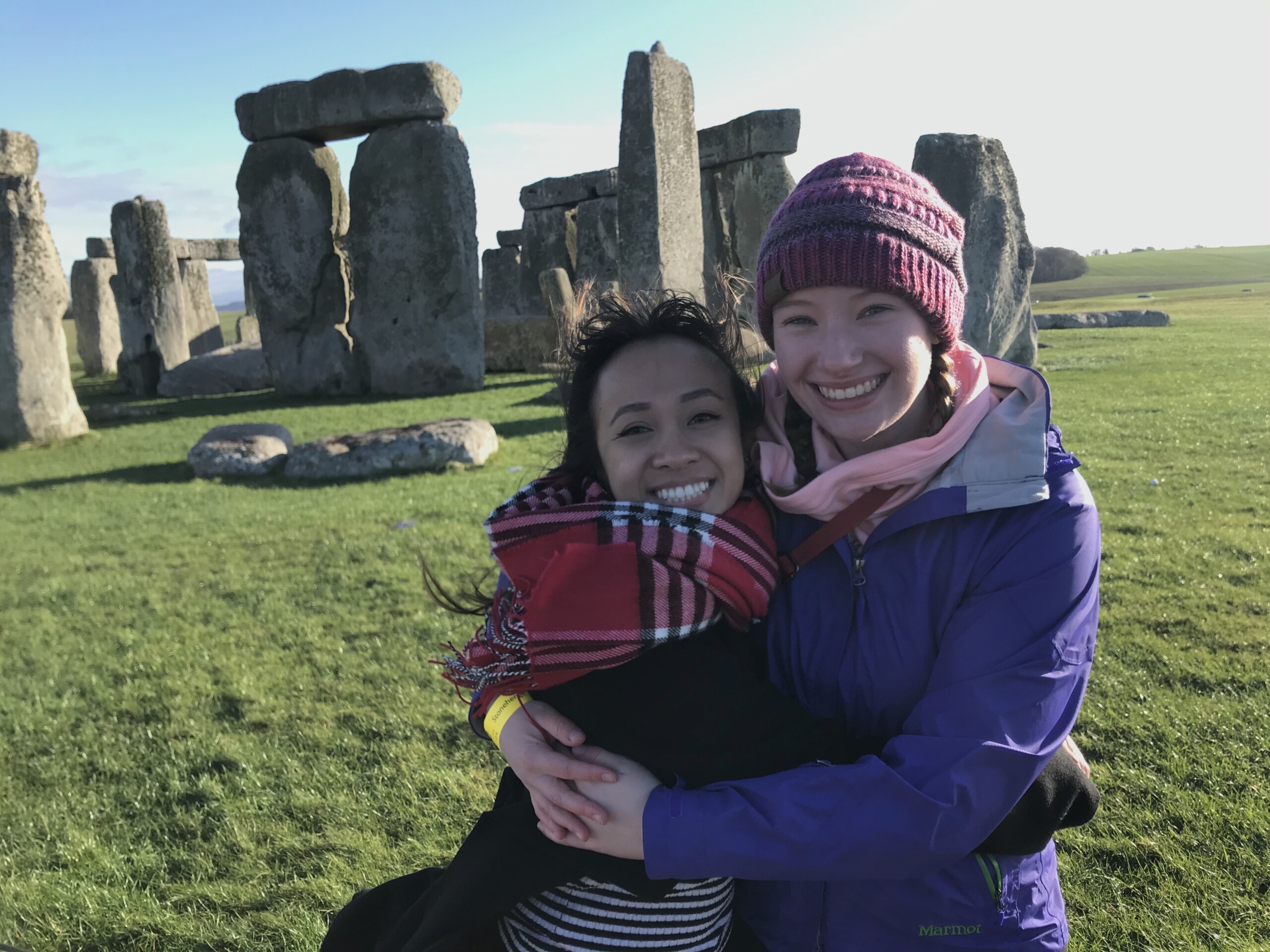 Students smile for a photo in front of Stonehenge in England.