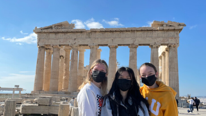 PLU students posing in front of historic ruin in Greece.