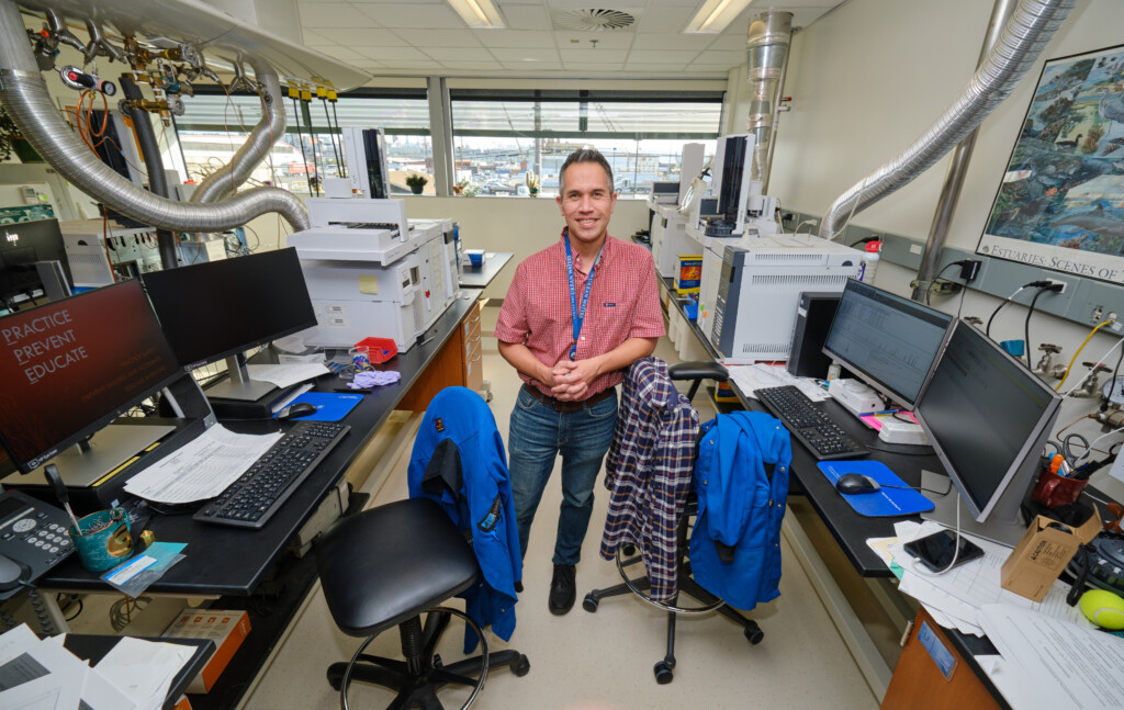 Tom Chontofalsky stands in the middle of his office, with computers and science equipment all around him