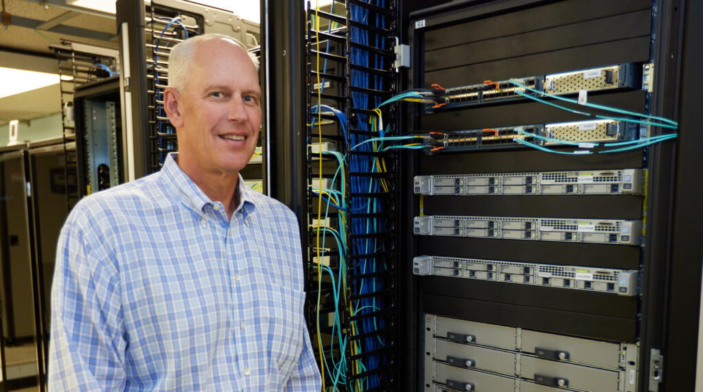 Mark Miller stands in front of a large circuit board behind-the-scenes at the Port of Tacoma