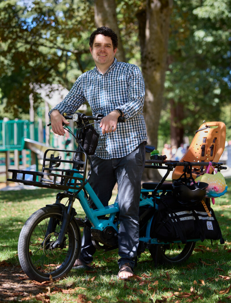 Andrew Austin smiles while standing over his bike in Tacoma's Wright Park