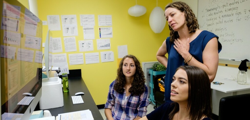 Two students and a faculty member of PLU looking at a computer monitor