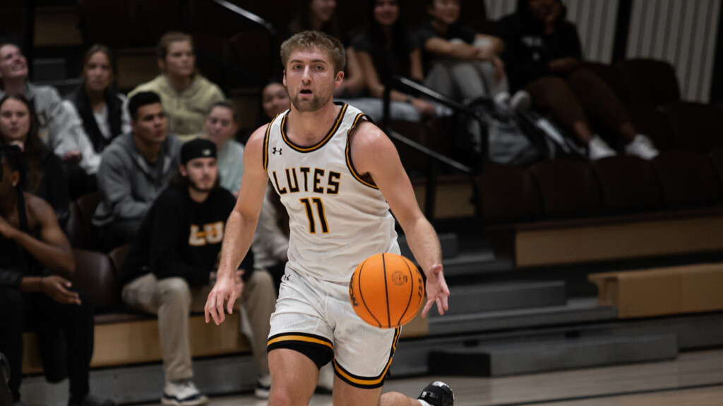 Jackson Reisner on the basketball court during a game. Jackson is dribbling the ball down court.