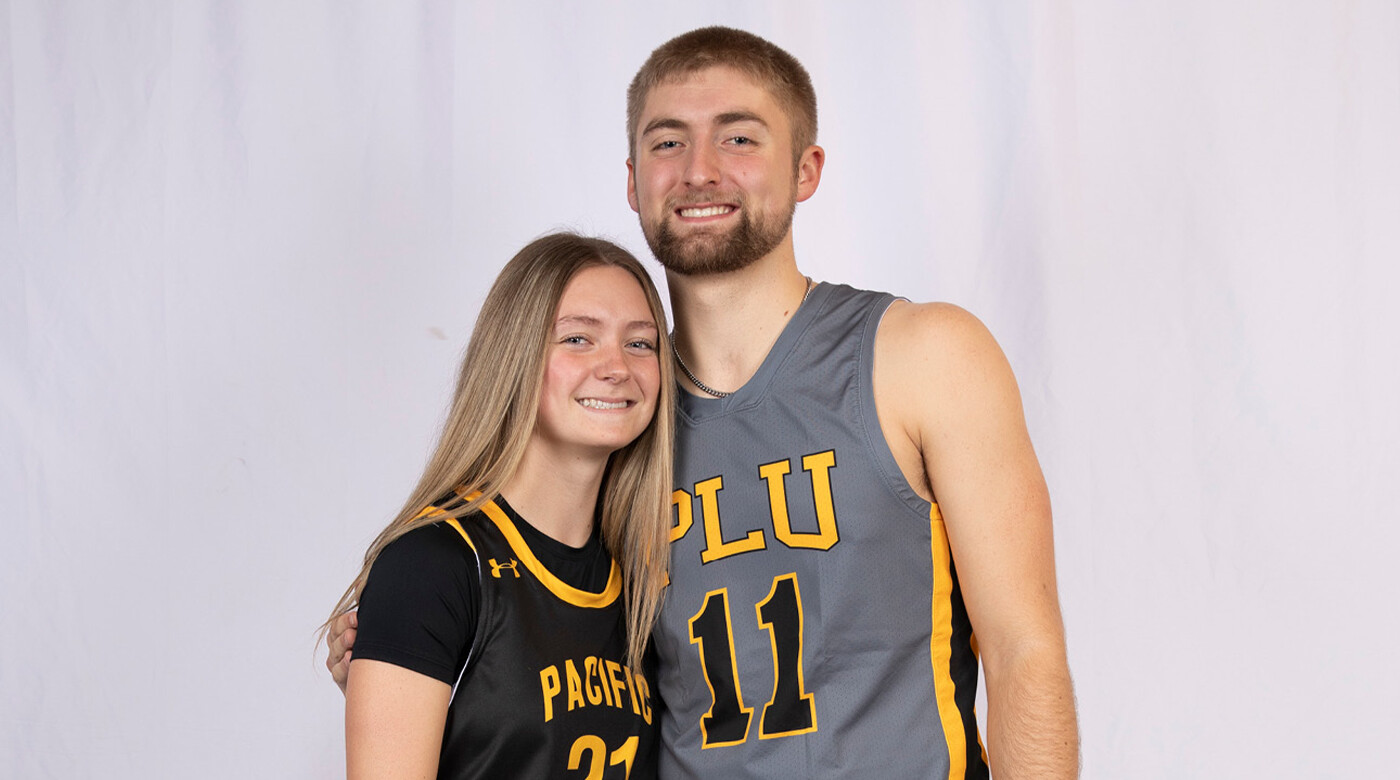 Siblings Sydney and Jackson Reisner posing in their basketball uniforms for an official portrait for PLU athletics.