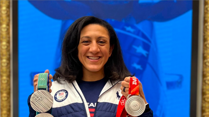 Elana Meyers Taylor poses with her Olympic medals. she is smiling and wearing a team USA jacket.