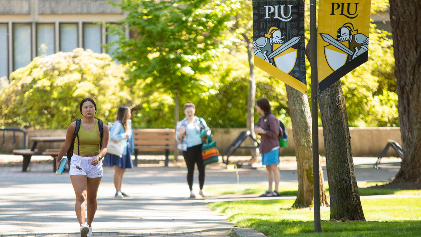 PLU students walk to class on upper campus on a summer spring day.