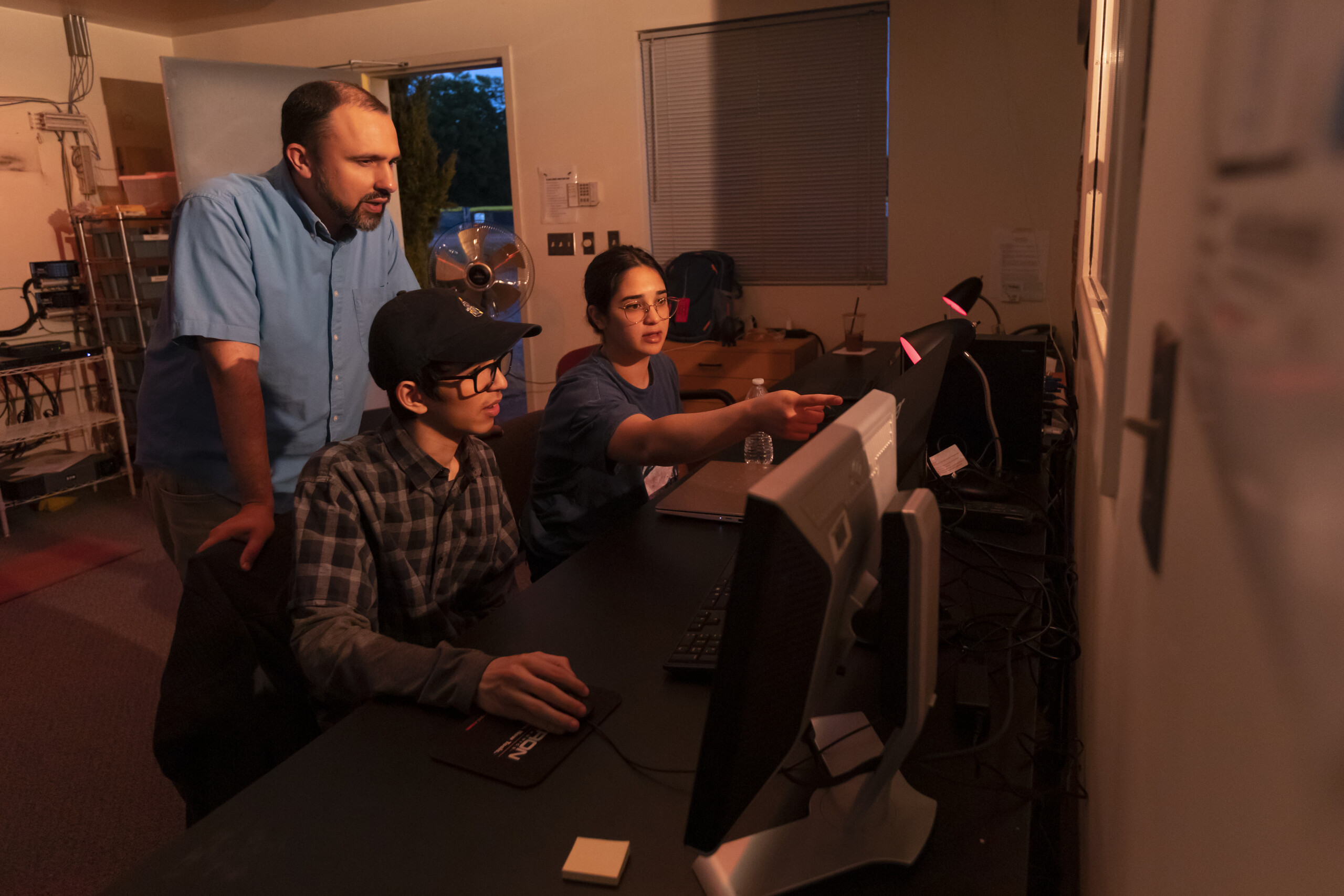 O'Neill looks on while interns discuss celestial image processing. Kop is making light curves, showing how the brightness of several variable stars changes over time. Ordaz captured images of globular clusters, constructing diagrams based on temperature and luminosity to estimate the age of these ancient clusters.