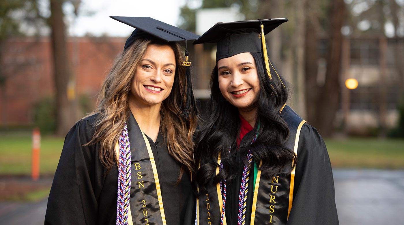 Stephanie Millet, a Navy veteran, and Raven Lopez, an Air Force veteran, pose for a photo after the School of Nursing Nurse Pinning, Saturday, Dec. 10, 2022, at PLU. (PLU Photo / Sy Bean)