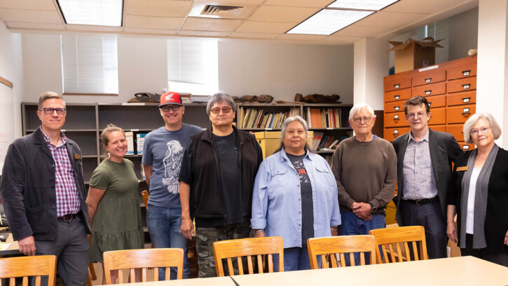 PLU and Nisqually leaders stand in a meeting room in PLU's Xavier hall.