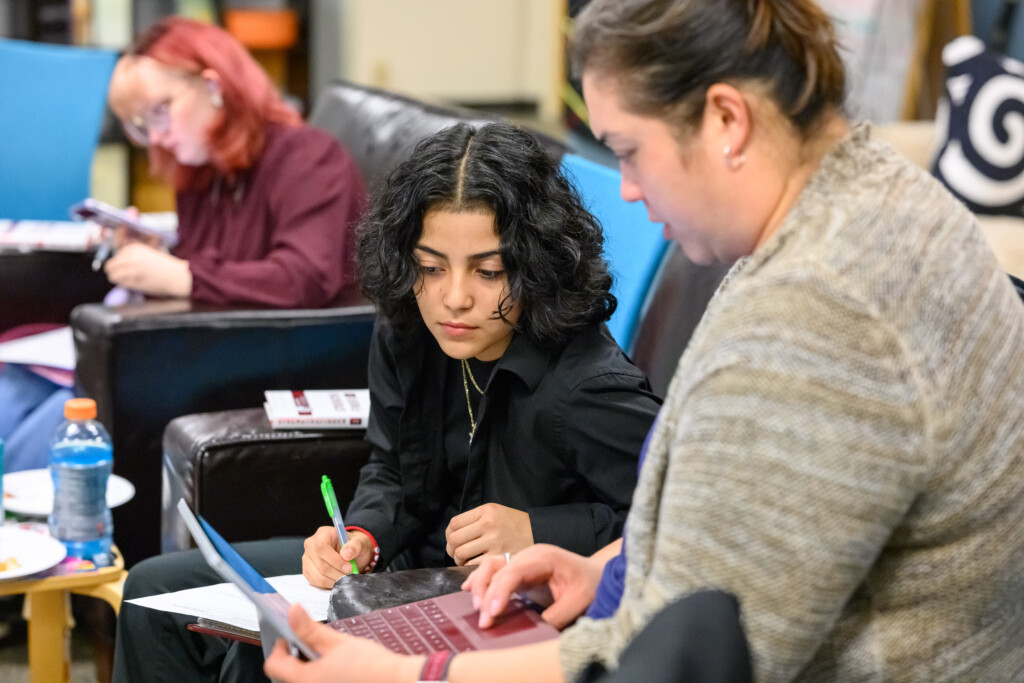 Two PLU students look at a lap top during a class.