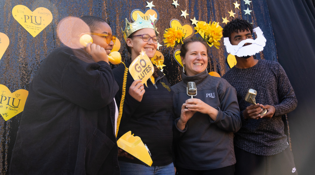 Four people pose for a photo for a photo booth.