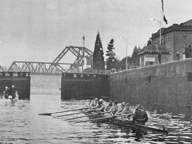 The PLU rowing team rows on Elliot bay. It is a black and white photograph.