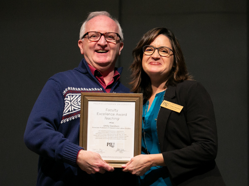 University President Allan Belton (left) presents Emily Davidson (right) with the 2023 Faculty Excellence Award in Teaching.