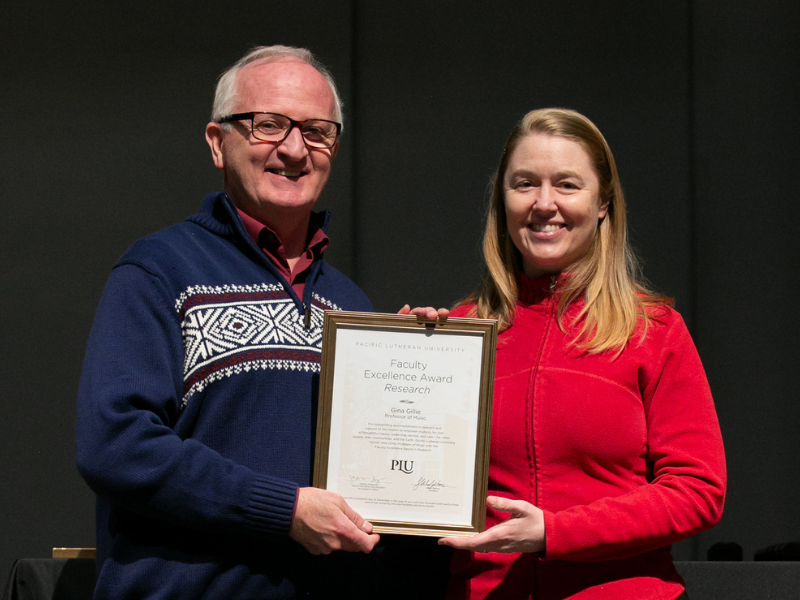 University President Allan Belton (left) presents Dr. Gina Gillie (right) with the 2023 K.T. Tang Faculty Excellence Award in Research.