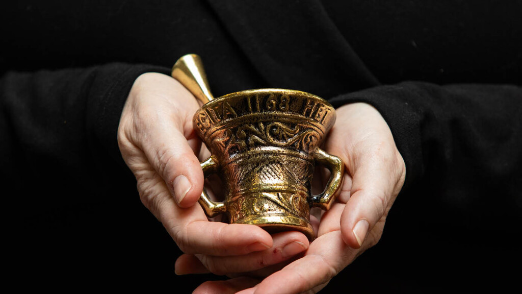 A close up photo of Brenda Llewellyn Ihssen's hands holding a small midevil golden cup.