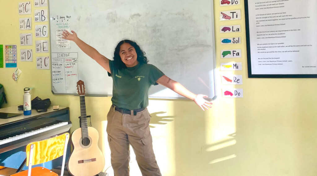 Jessa smiling and holding her hands up in the classroom she taught in Namibia