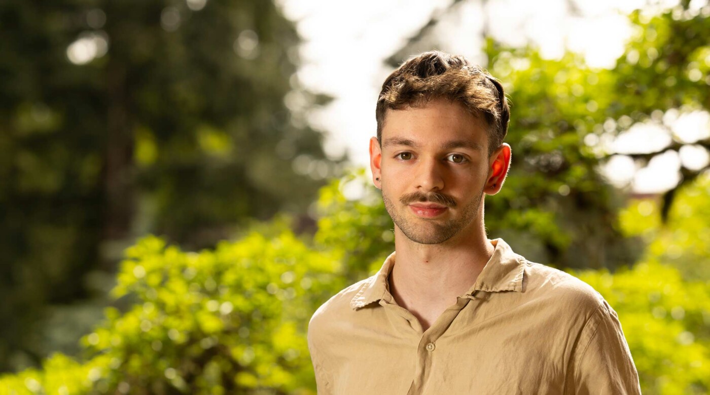 Ivan Wilson, Art Director for the student run creative agency Impact, poses for his senior spotlight portrait, Tuesday, May 6, 2025, outside the AUC at PLU. (PLU Photo / Sy Bean)