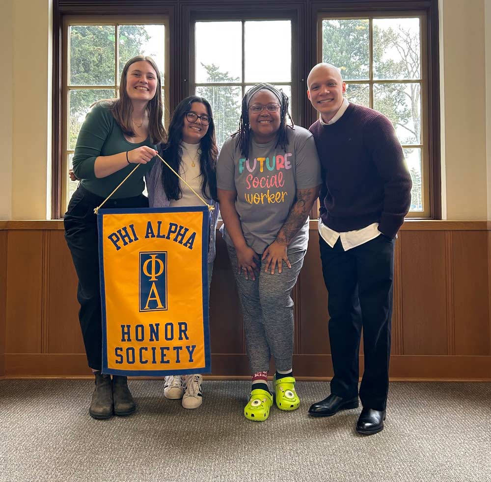 Zoneice Grose and classmates hold Phi Alpha Honor Society banner.