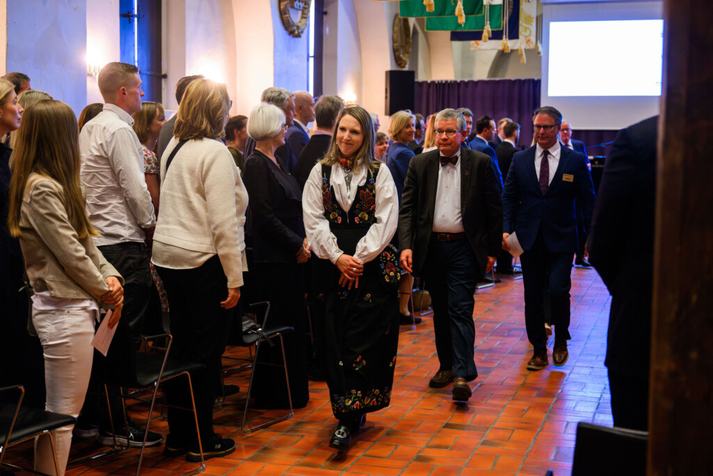 PLU alumni walks down an aisle to leave the event in Norway