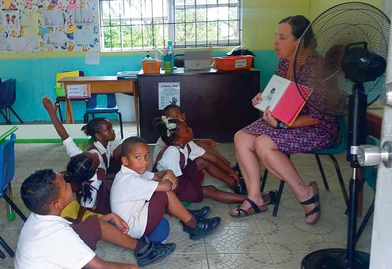 Amy Siegesmund sitting and reading aloud in front of a group of students