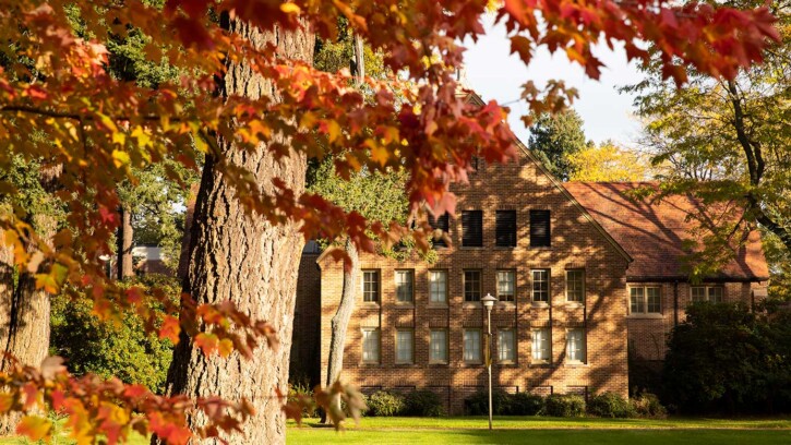 Fall on campus at Pacific Lutheran University, with a tree in the foreground and a building in the background. (PLU Photo / Sy Bean)