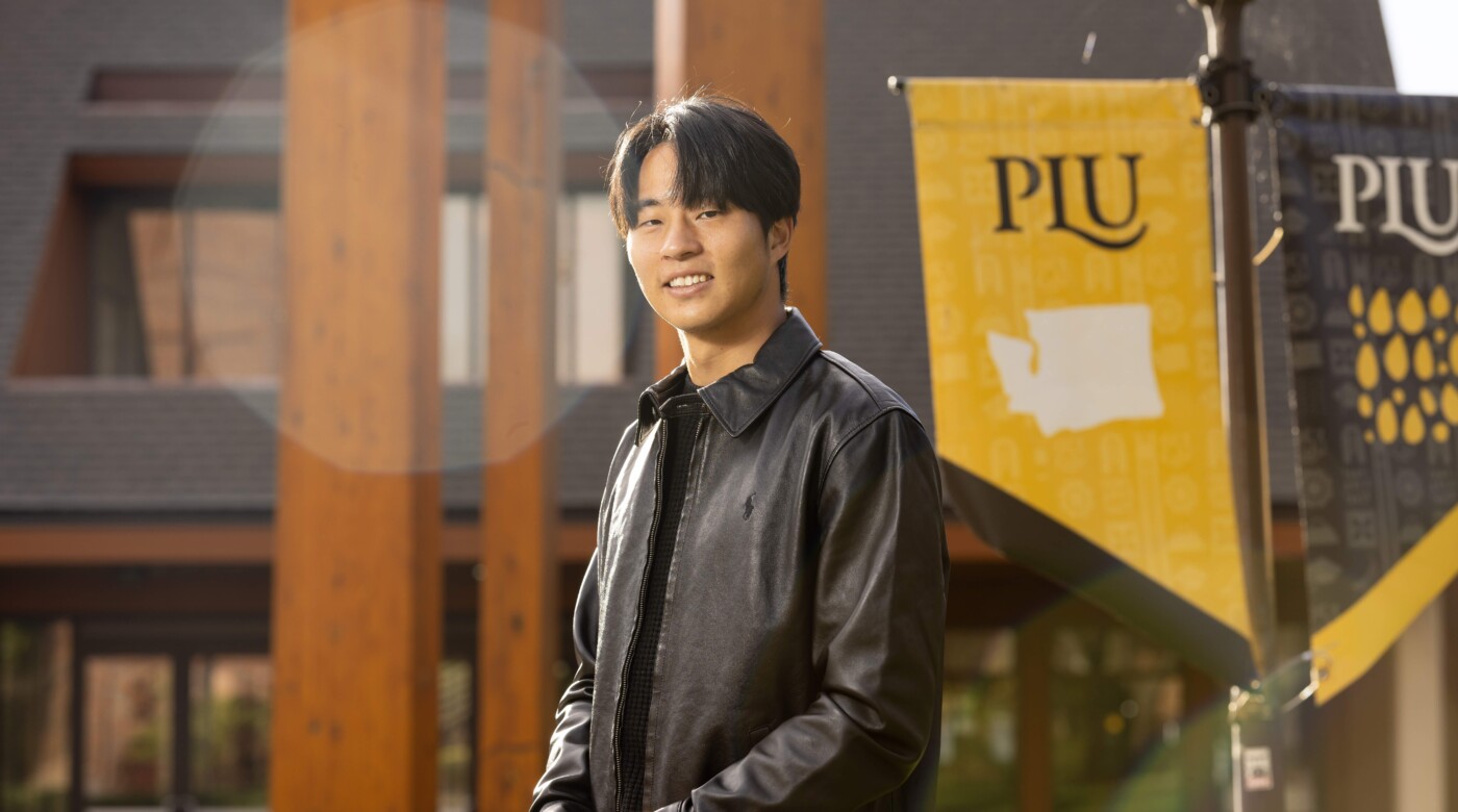Yuta Shimazu smiles at the camera in front of Anderson University Center at PLU.
