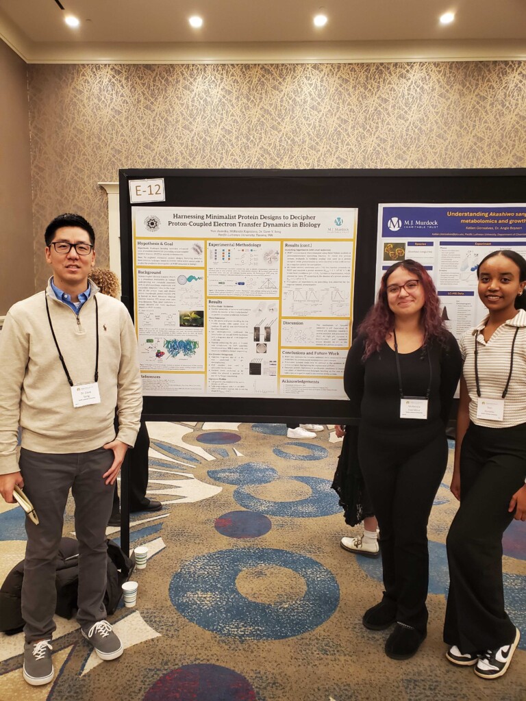 Faculty member Dave Song and PLU students McKenzie Kapalova and Yom Aymeku pose in front of their poster presentation at the 2025 Murdock Conference.