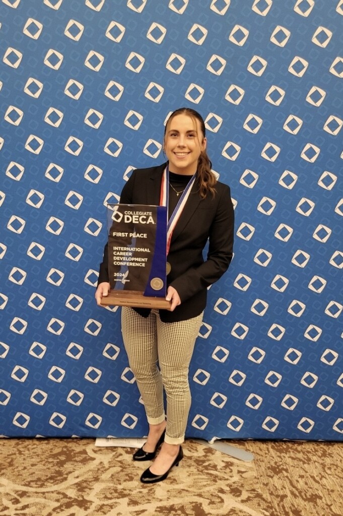 Carmen poses with award.