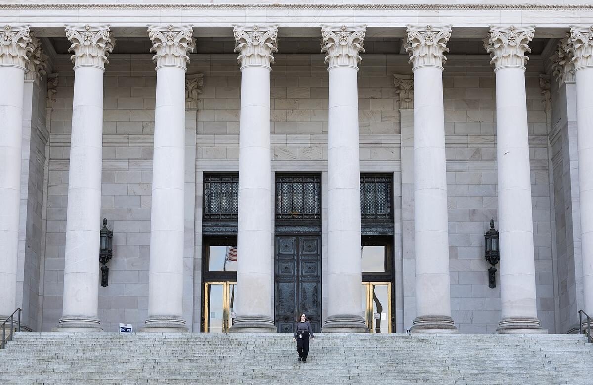 Student stands on the top steps of the Washington state capitol building.