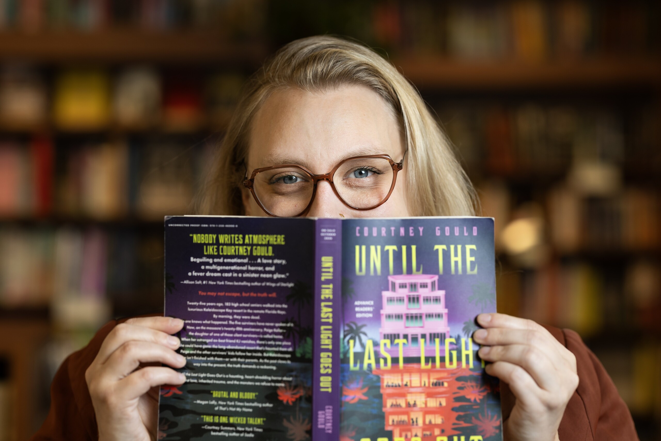 Gould holding her upcoming book in Grit City Bookstore.