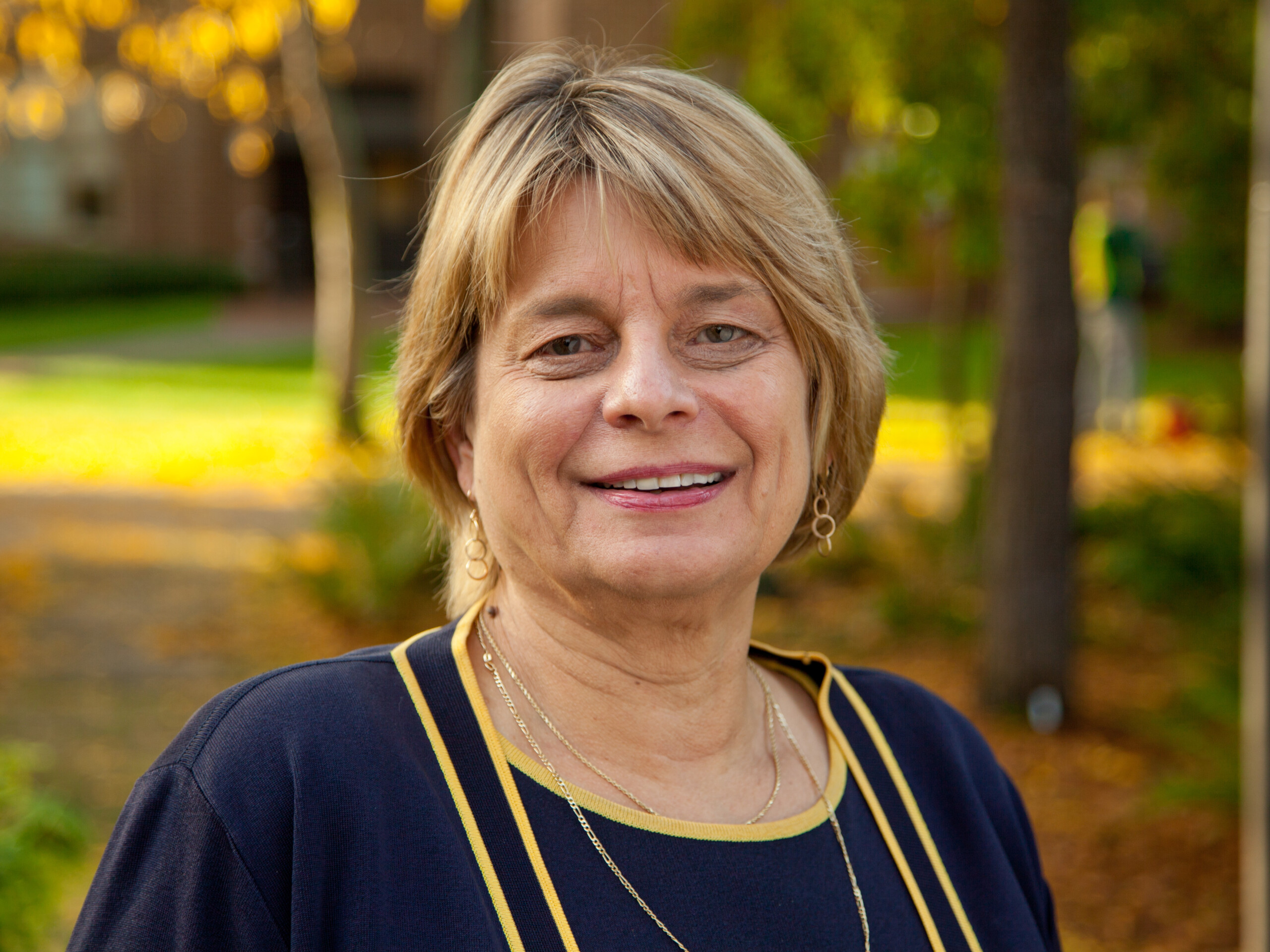 Sheri Tonn, in blonde hair and a dark blue shirt, smiles for a photo on a fall afternoon in 2012.